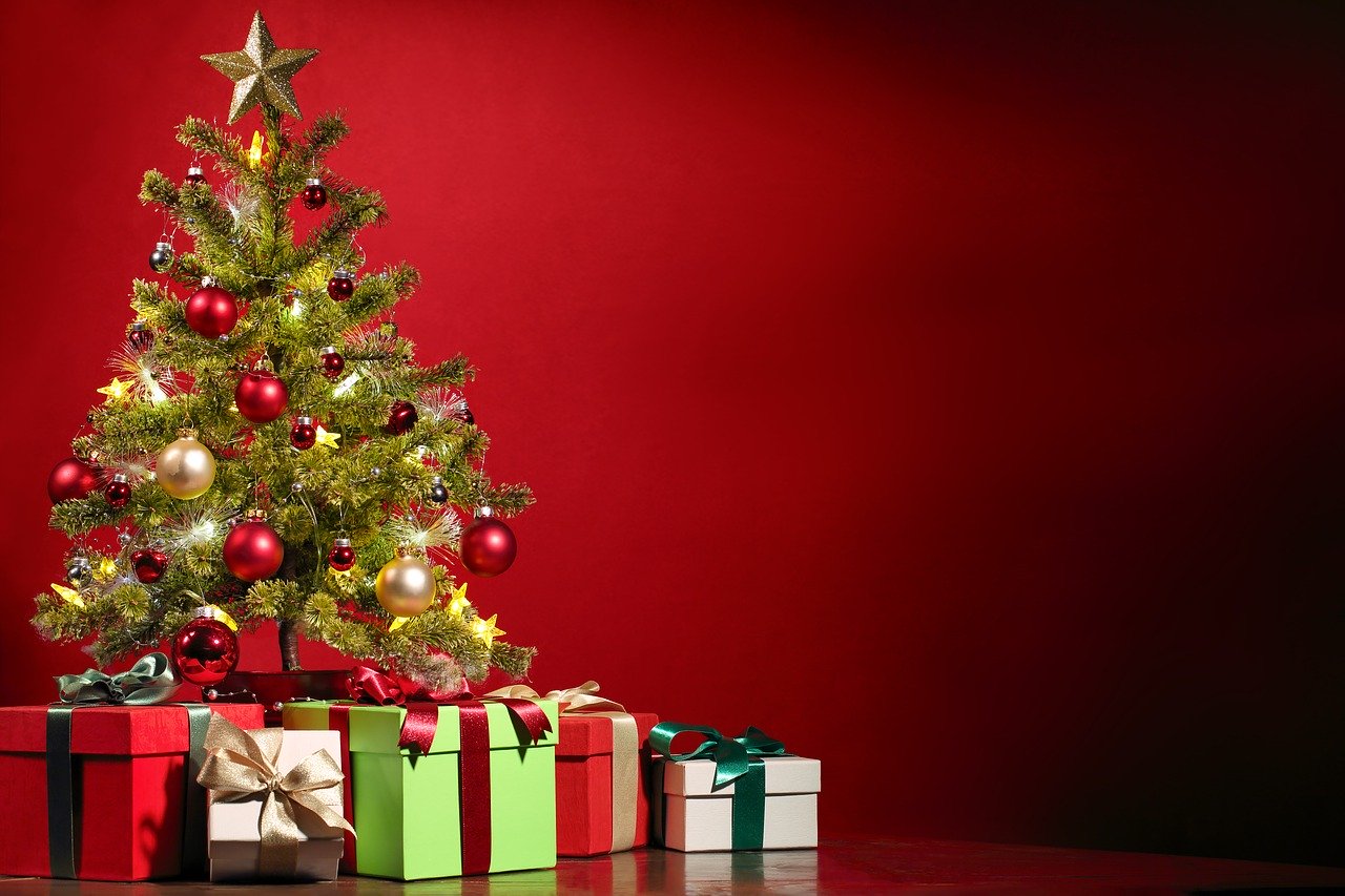 Weihnachtsbaum mit Geschenken vor roten Hintergrund